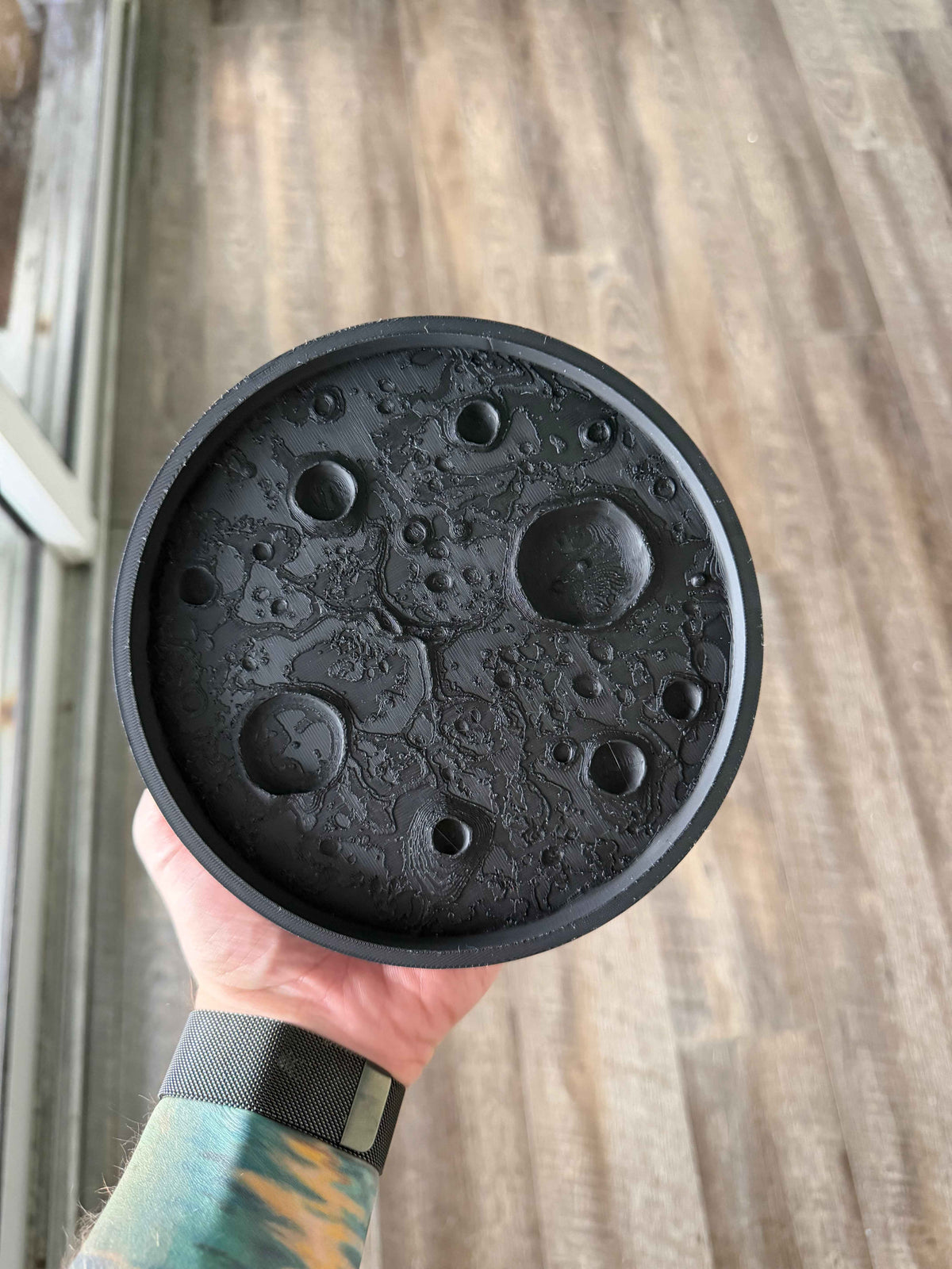 Matte black 3D printed moon tray with lunar surface texture holding small items