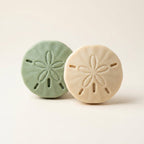 Two handmade sand dollar shaped soap bars from the Coastal Calm collection