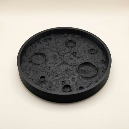 Matte black 3D printed moon tray with lunar surface texture holding small items
