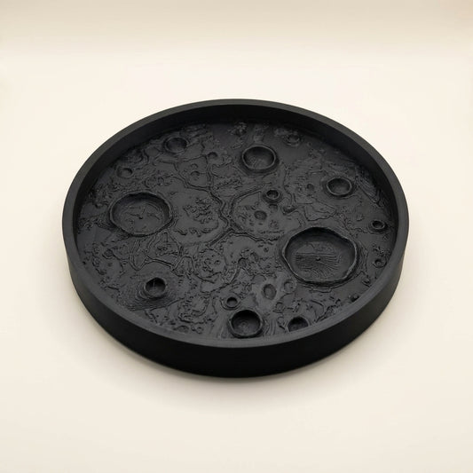 Matte black 3D printed moon tray with lunar surface texture holding small items