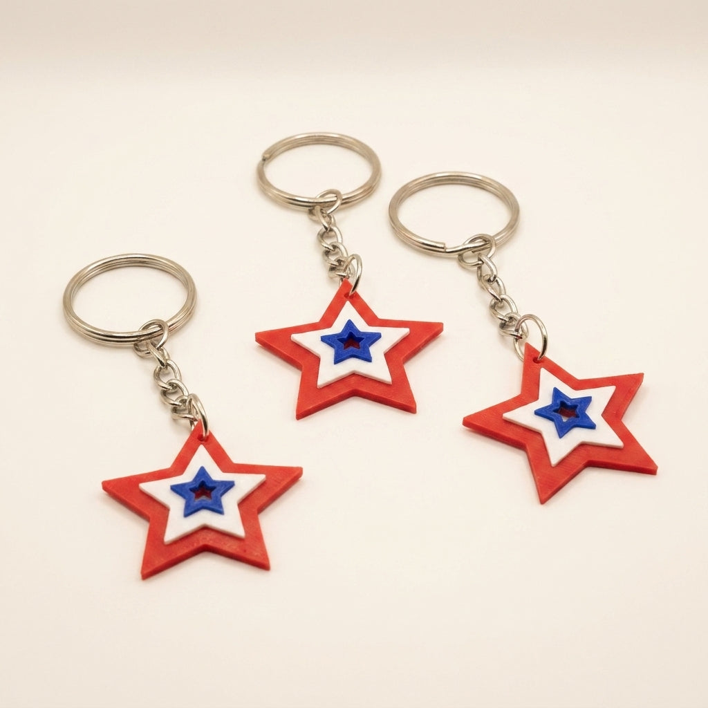 Set of three 3D printed star keychains in red, white, and blue